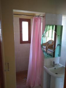 Łazienka wyposażona jest w różową zasłonę prysznicową i umywalkę. w obiekcie CFM Sociedade Turística Bilene Resort w mieście Vila Praia Do Bilene