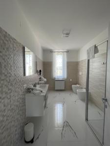 a white bathroom with a sink and a toilet at OrizzonteMare in Ortona