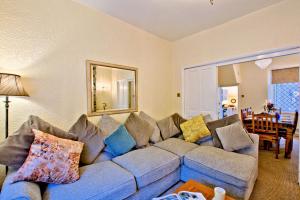 een woonkamer met een blauwe bank met kussens bij Labernum Cottage, Ingleton, Yorkshire Dales National Park, Famous Three Peaks, Near The Lake District, Pets Are Welcome in Ingleton 