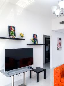 a living room with a large flat screen tv on a wall at Luxury Hotel Apartment Mall of Emirates in Dubai