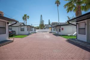 a brick parking lot with houses and palm trees at C6-Manatee in St Pete Beach