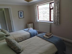 1 dormitorio con 2 camas y ventana en Thie-Ny-Soalt, en Colby