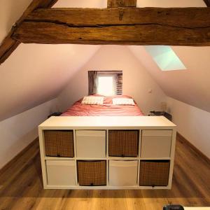 Le Cocon Perché - Nid Secret في Longny-au-Perche: غرفة نوم مع سرير في العلية