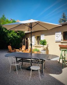 a picnic table with an umbrella and two chairs at The Gate House & Winery in Santenay