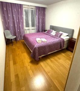 - une chambre avec un lit doté de draps violets et une fenêtre dans l'établissement Real deal apartments Tampere, à Tampere