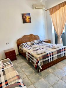 um quarto com uma cama com um cobertor xadrez em Hotel Adriatik Shengjin em Shëngjin