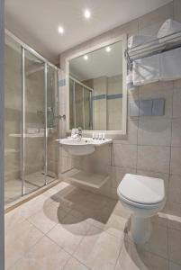 a bathroom with a toilet and a sink and a shower at AQUAMARE CITY and BEACH in Rhodes Town
