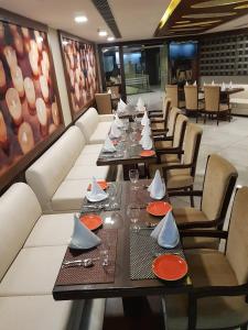 a dining room with tables and chairs with plates and napkins at VRC CITY HEART in Bathinda