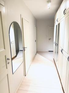 an empty hallway with a mirror and white doors at Real deal apartments Tampere in Tampere