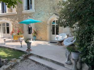 a patio with a blue umbrella in front of a building at La Chapelle in Orange +14 photos