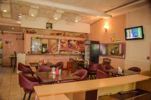 a restaurant with tables and chairs and a bar at Kericho Pride Hotel in Kericho