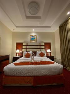 فندق زهرة الربيع zahrat alrabie Hotel في جدة: غرفة نوم بسرير كبير عليها حيوانين