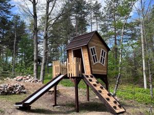 a wooden playground with a slide in the woods at Vikendica Martinović in Divčibare