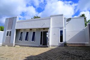 un edificio blanco con puertas abiertas en JOSELLA MOTEL MUBENDE, en Mubende