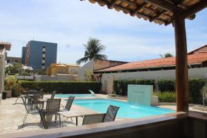 um pátio com cadeiras e uma piscina em Marezzi Hotel Aracaju em Aracaju
