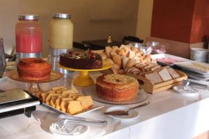 - une table avec différents types de gâteaux et de pâtisseries dans l'établissement Marezzi Hotel Aracaju, à Aracaju