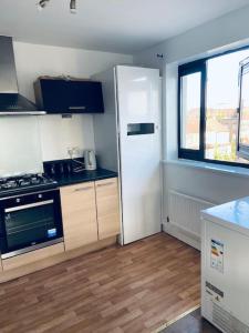 a kitchen with a white refrigerator and a window at Bally, 2 Bed Flat, by Grays Station in Stifford