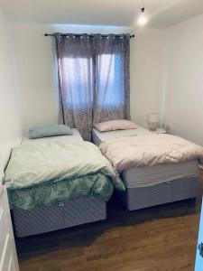 two twin beds in a room with a window at Bally, 2 Bed Flat, by Grays Station in Stifford