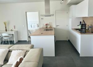 a living room with a couch and a kitchen at Paradis Express - Guillemins Station Luxury Flat in Liège
