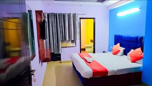 a bedroom with a bed with red and blue at Hotel Happy Residency-Sainik Farms in New Delhi