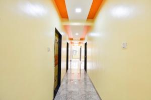 a hallway with white walls and orange ceilings at OYO Hotel Boss Lodging in Aurangabad