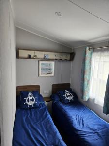 um pequeno quarto com duas camas num barco em Haven Kent Coast Allhallows 3 bed em Allhallows