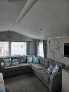 a living room with a large couch in a room at Haven Kent Coast Allhallows 3 bed in Allhallows
