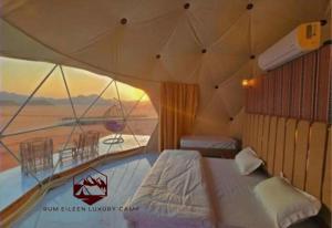 a bedroom with a tent with a view of the desert at RUM EiLEEN LUXURY CAMP in Wadi Rum