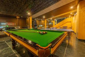 a pool table in a large room with a pool table at Hill Rive Resort Near Mall Road in Manāli