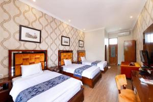 Habitación de hotel con 2 camas y escritorio en NIWA CANTING en Brumbung