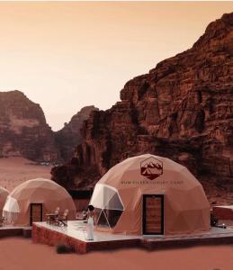 un gruppo di tende nel deserto con montagne di RUM EiLEEN LUXURY CAMP a Wadi Rum