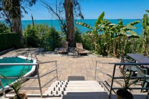un patio con 2 bancos y una piscina en Villa Lile, en Batumi