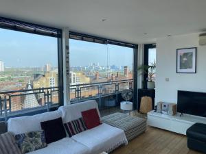 a living room with a couch and large windows at Penthouse in Battersea amazing views of London in London