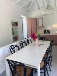 a dining room with a white table and chairs at The Bellhouse Kranidi in Kranidi