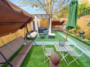 einen Hinterhof mit einem Sonnenschirm und Stühlen und einem Basketball in der Unterkunft 3Bed 2Bath with Garden sauna & Hot Tub in London