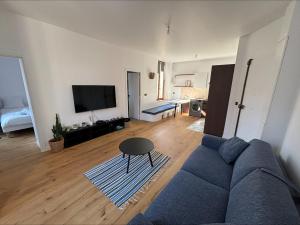 a living room with a blue couch and a tv at Bakara, élégant t2 au cœur des Halles de Biarritz in Biarritz