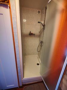 um chuveiro com uma porta de vidro na casa de banho em L'Hôtel du Mouton blanc em Fresne-Saint-Mamès