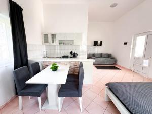 una cucina con un tavolo bianco e sedie in una stanza di Sunside Apartments a Pola (Pula)