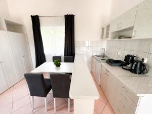 una cucina bianca con tavolo e sedie bianchi di Sunside Apartments a Pola (Pula)