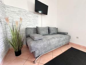 un divano in camera con TV a parete di Sunside Apartments a Pola (Pula)