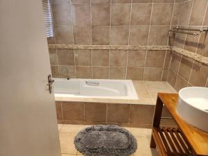 a bathroom with a bath tub and a sink at Valley Inn Guest House, Accommodation 6, Drakenstein Avenue in Sandown