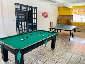 due tavoli da biliardo con le palle in una stanza di Chácara piscinas incríveis, próximo a são paulo. a Mairinque