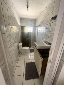 La petite salle de bains est pourvue de toilettes et d'un lavabo. dans l'établissement Chácara piscinas incríveis, próximo a são paulo., à Mairinque