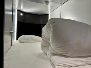 Postel nebo postele na pokoji v ubytování Capsule Hotel Suzumoriya