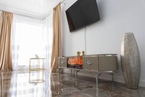 een woonkamer met een flatscreen-tv aan de muur bij Jacuzzi & luxury house in Iaşi