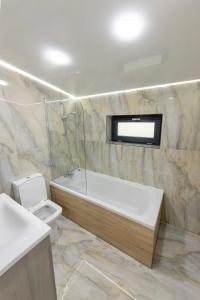 ein Badezimmer mit einer Badewanne, einem WC und einem Waschbecken in der Unterkunft Jacuzzi & luxury house in Iaşi