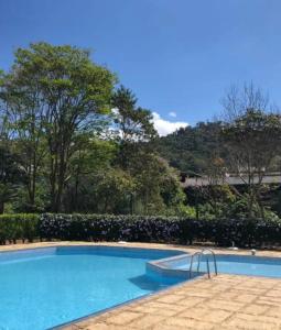 a swimming pool with a mountain in the background at Lagos de Itaipava in Bom Sucesso