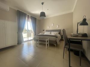 una camera da letto con un letto, un tavolo e una scrivania di Casa Karina a Battipaglia