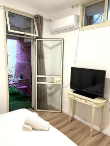 een woonkamer met een televisie en een tafel met een televisie bij Ramban Emerald in Haifa