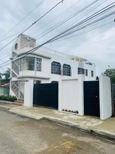 um edifício branco com duas portas de garagem numa rua em Apartamentos ipap luperon em Puerto de Luperon